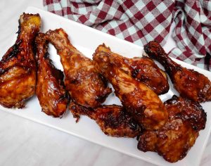 Remove the cooked BBQ chicken from the air fryer and use the ½ cup of BBQ sauce to coat the chicken with a second brushing of BBQ sauce.