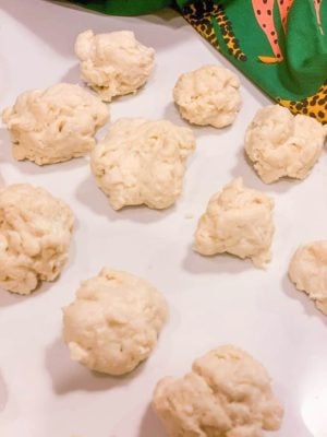 Fluffy chicken and biscuit dough balls on a white surface for Southern comfort baking.