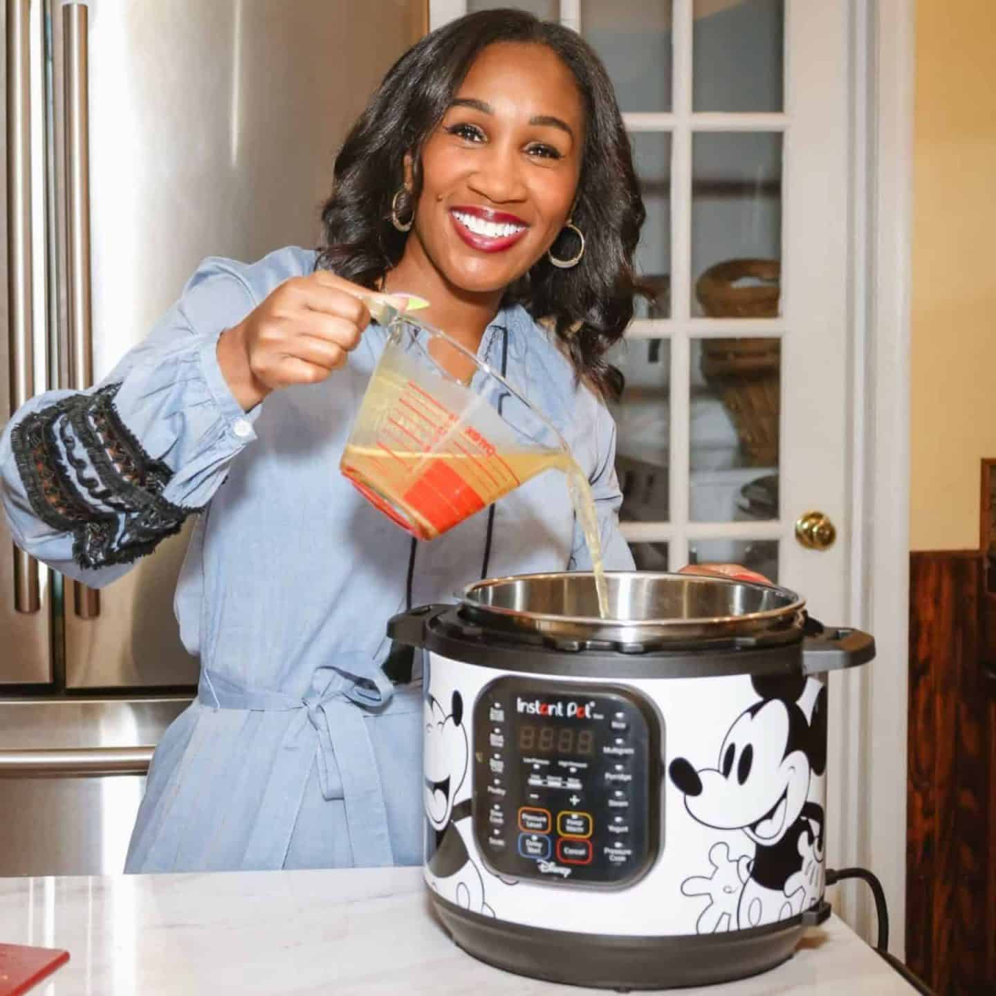 Shaunda Necole pouring seasoned broth into a Disney Instant Pot in her home kitchen while preparing authentic Southern soul food recipes the modern way for TheSoulFoodPot.com