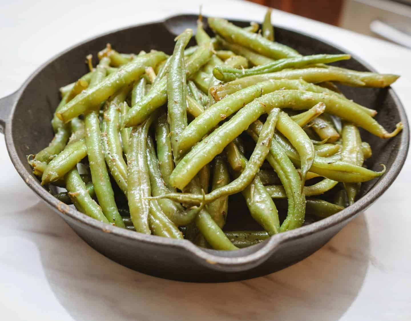 How tender should soul food green beans be? Close-up of tender Southern green beans cooked the soul food way, softened and infused with seasoned broth for deep savory flavor, by Shaunda Necole of The Soul Food Pot®.