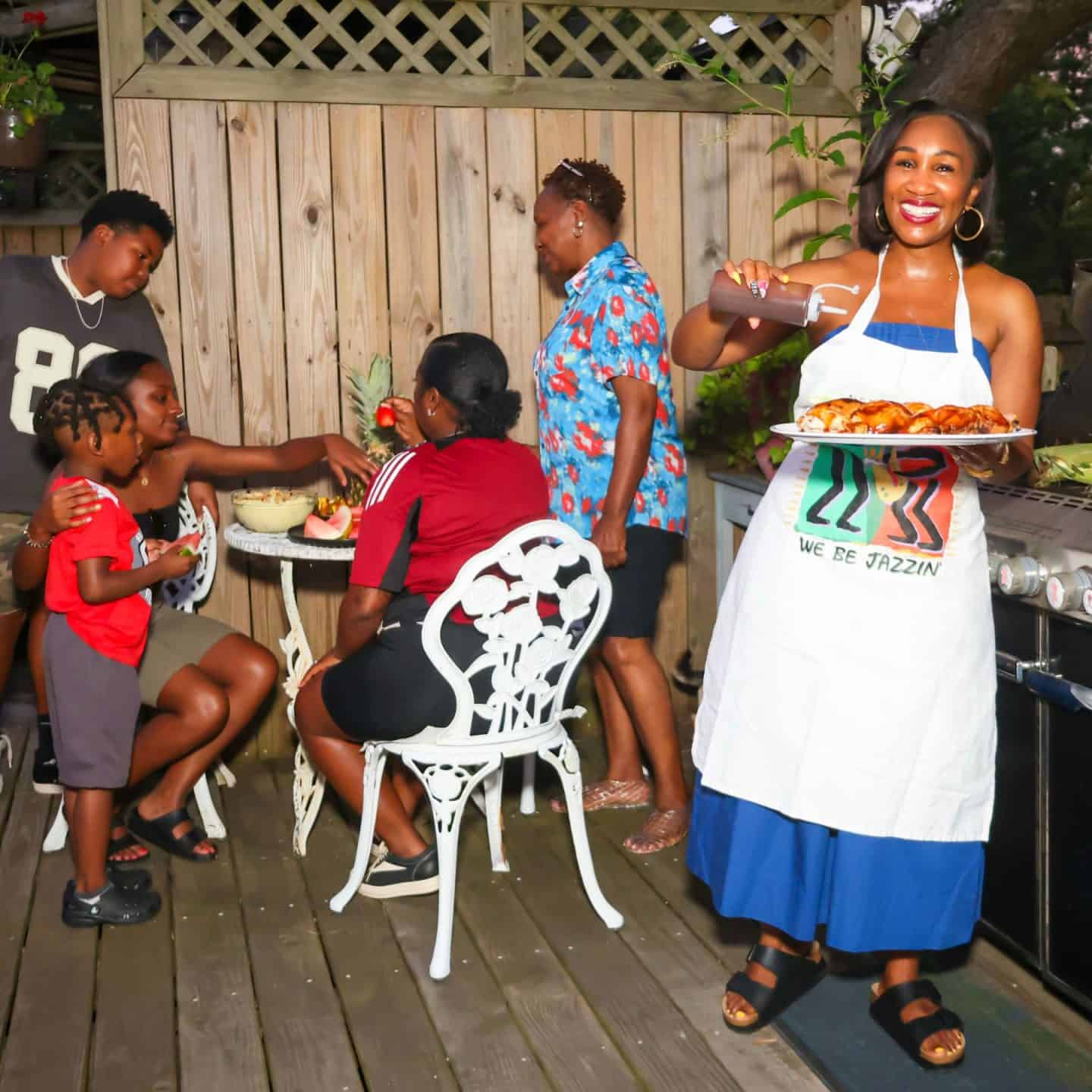 The evolution of soul food - from survival to celebration: Cookbook author Shaunda Necole of The Soul Food Pot&reg; is serving barbecue chicken at an outdoor family gathering, representing how soul food evolved from survival cooking into celebration food and a centerpiece of Black community life.