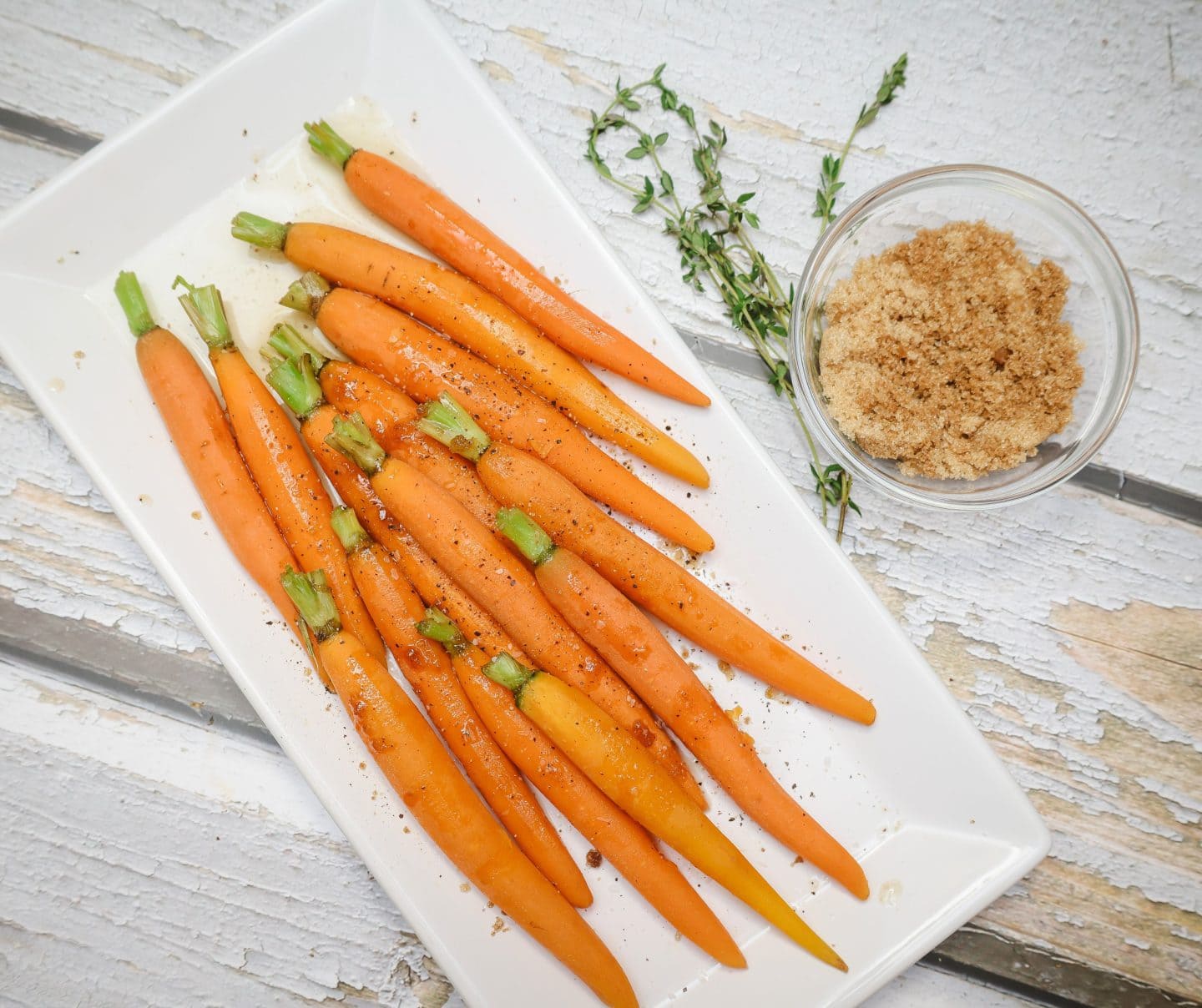 Old-fashioned Southern brown sugar–glazed carrots simmered on the stovetop with butter and thyme, glossy and fork-tender on a white platter, by Shaunda Necole of The Soul Food Pot®.