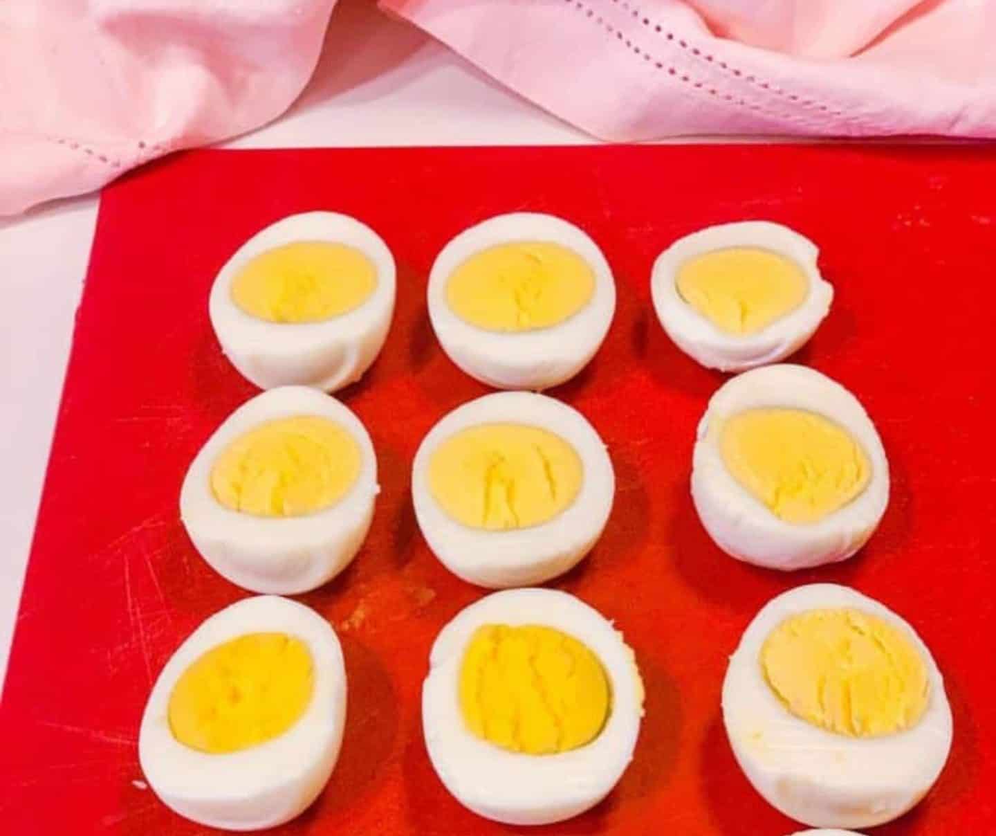 Hard-boiled eggs sliced in half with yolks intact, showing the perfect doneness for making Southern deviled eggs in this Black folks’ recipe by The Soul Food Pot®