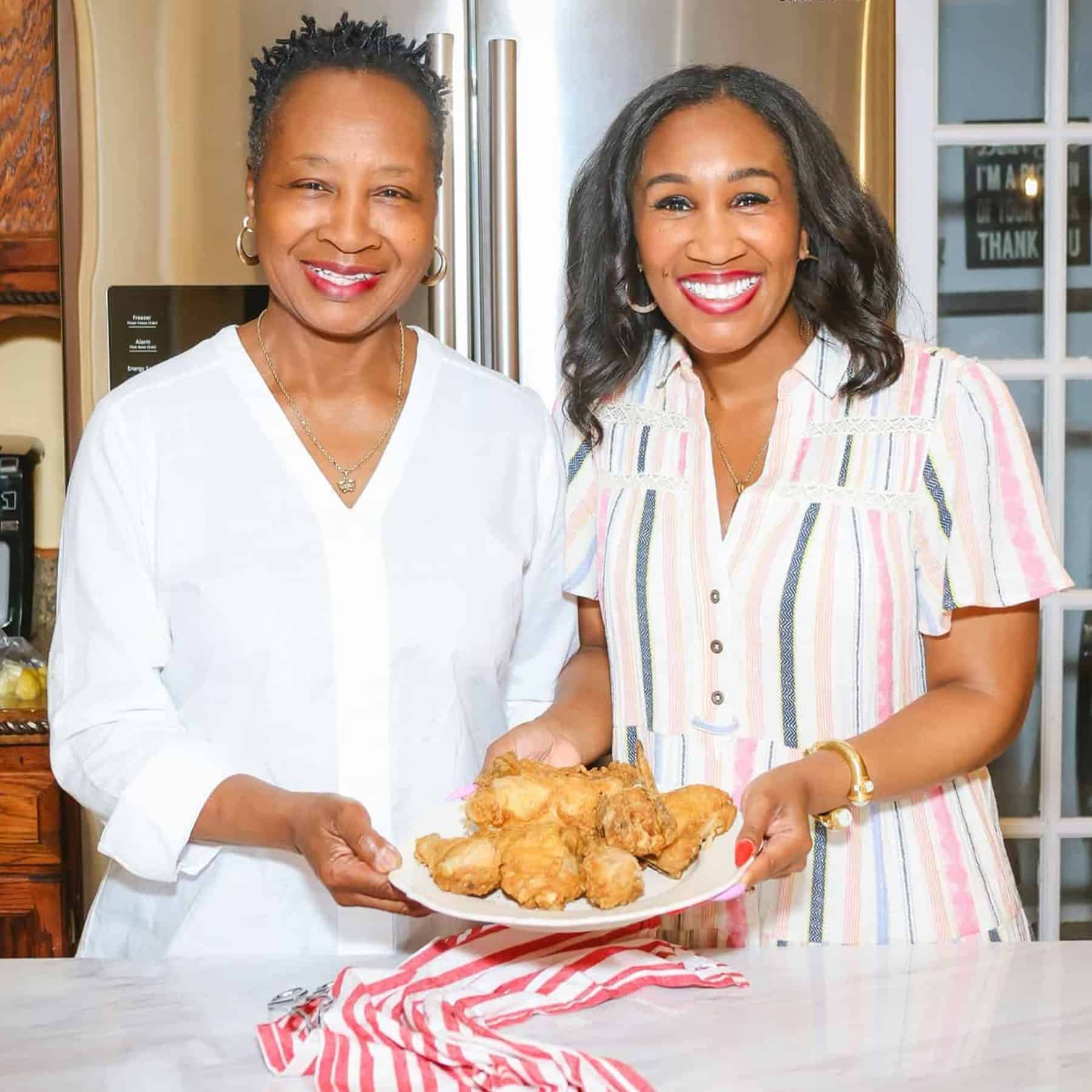 Soul Food Mother's Day - Shaunda Necole and her mom: Shaunda Necole and her mother sharing a plate of Southern fried chicken in the kitchen — celebrating African American culinary heritage and multi-generational soul food traditions with The Soul Food Pot®.