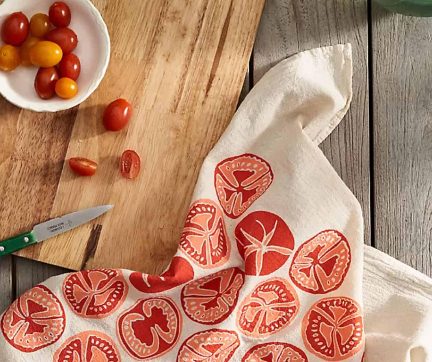 Anthropologie Home dish towels with tomato print styled on a wooden cutting board with fresh tomatoes, featured in The Soul Food Pot® Southern kitchen decor favorites