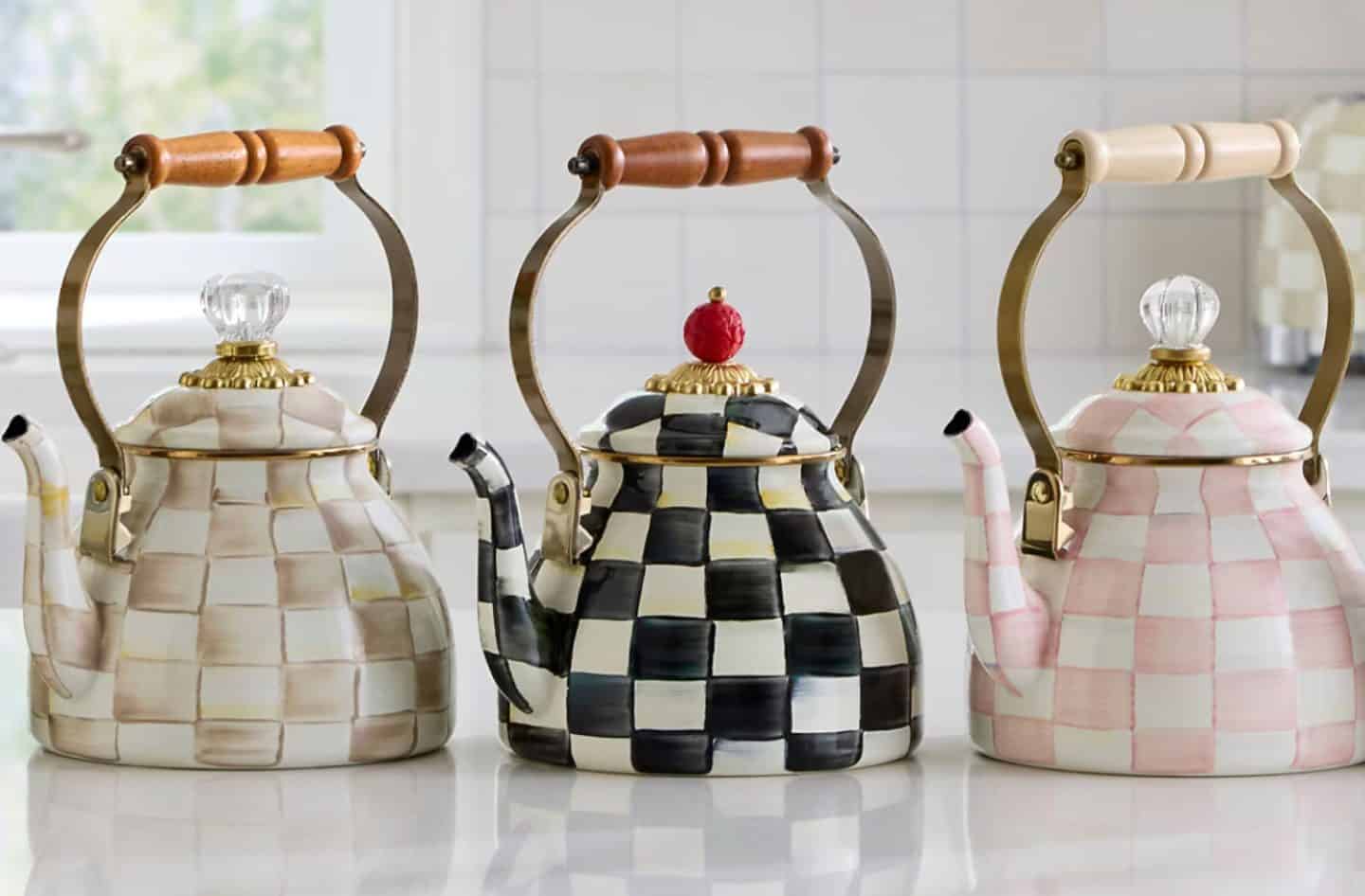 MacKenzie-Childs classic tea kettles in Courtly Check and pastel designs displayed on a kitchen counter, featured in The Soul Food Pot® Southern kitchen decor collection