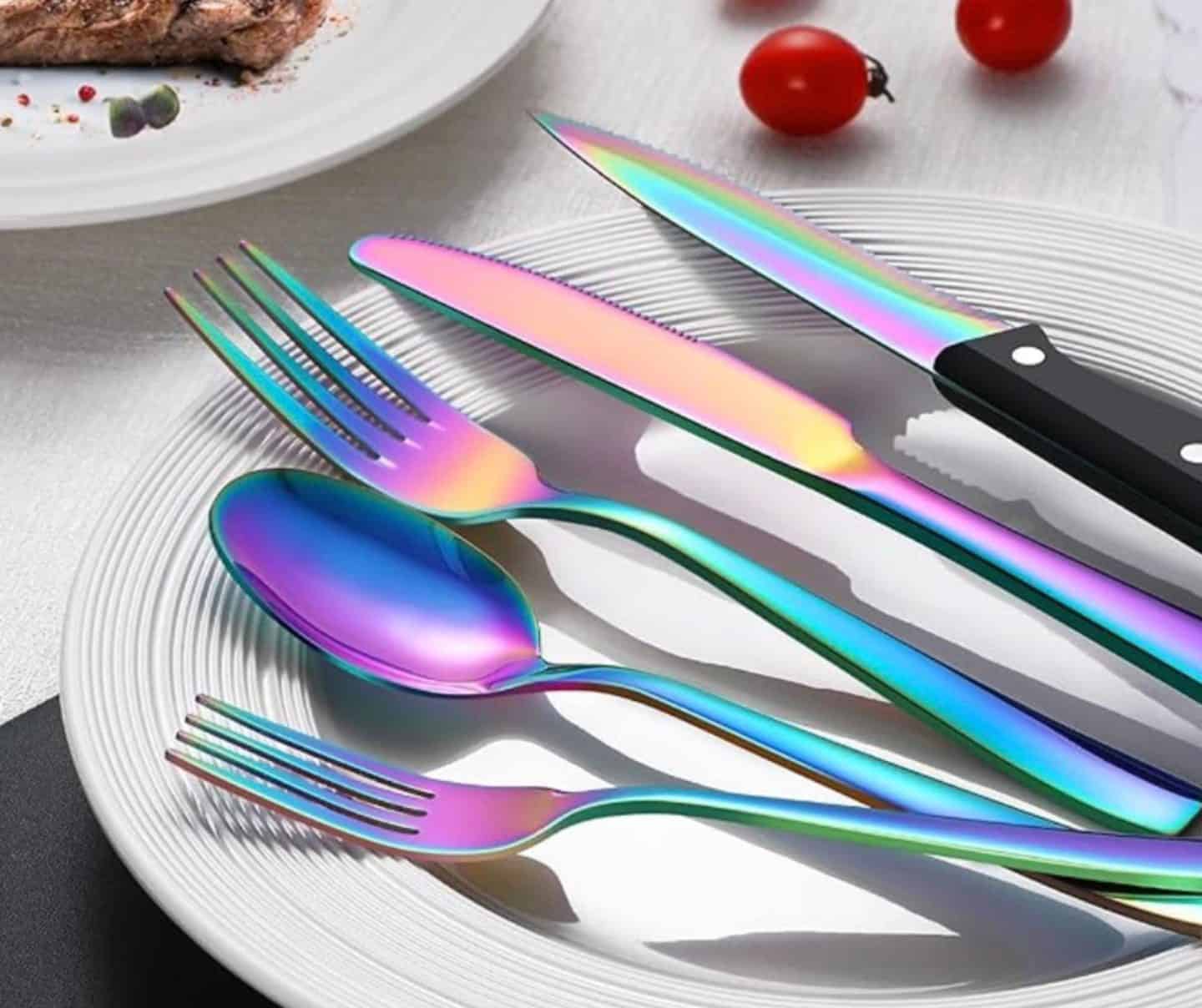 Rainbow stainless steel silverware set with iridescent finish styled on a white plate, featured by The Soul Food Pot® as modern Southern kitchen decor to elevate everyday dining and holiday table settings