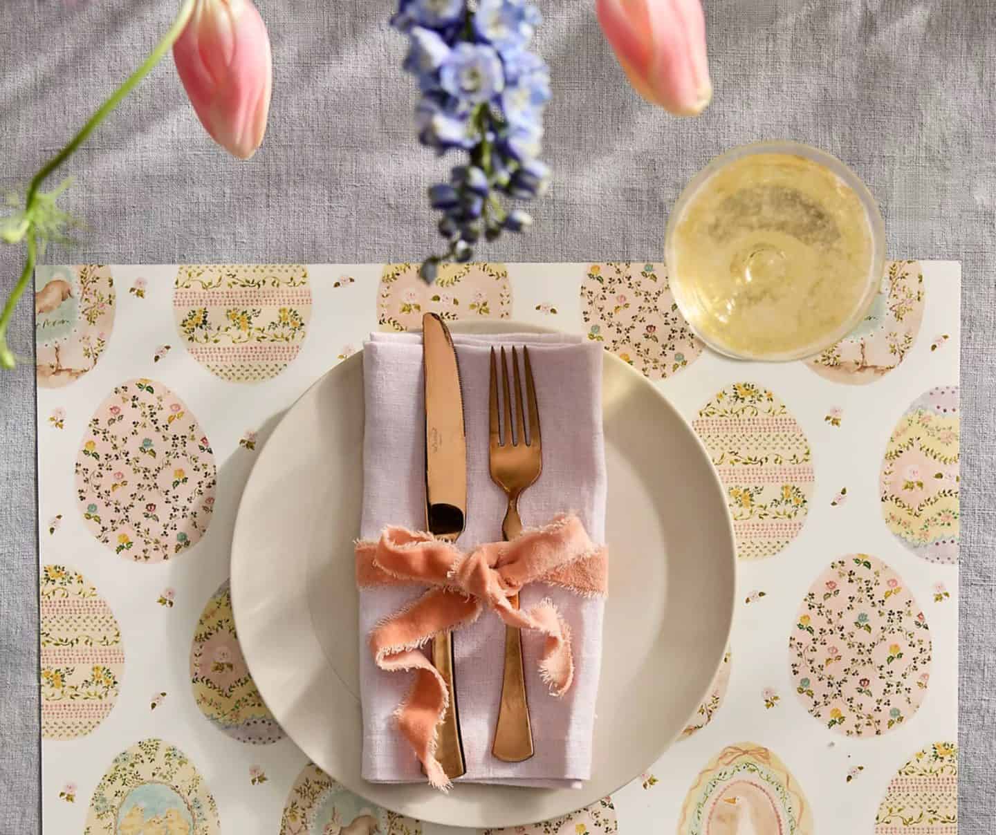Easter place setting with decorative egg-pattern placemat, folded napkin, and gold flatware, styled by The Soul Food Pot® for elegant Southern holiday dining