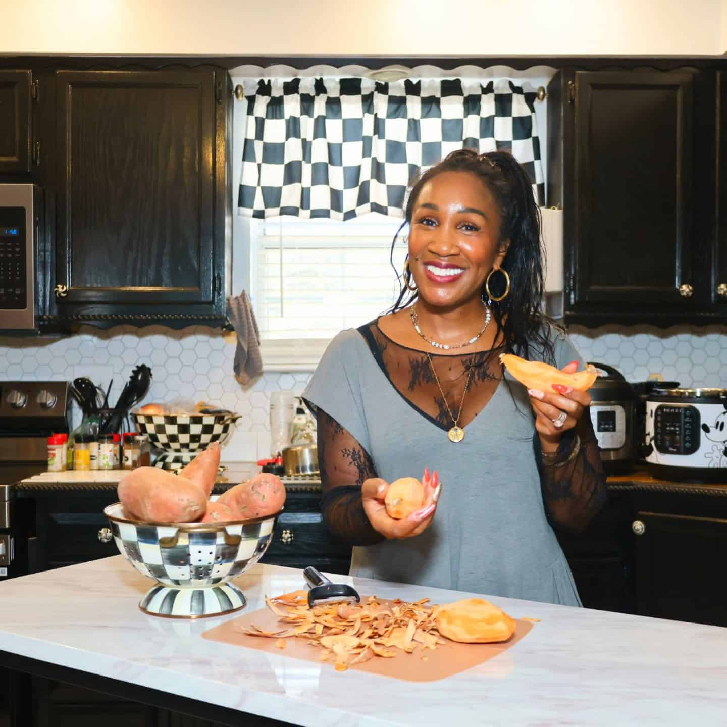 What I Actually Use in My Kitchen: Shaunda Necole peeling sweet potatoes in her kitchen with MacKenzie-Childs cookware and kitchen tools featured in The Soul Food Pot® Shop for soul food cooking essentials.