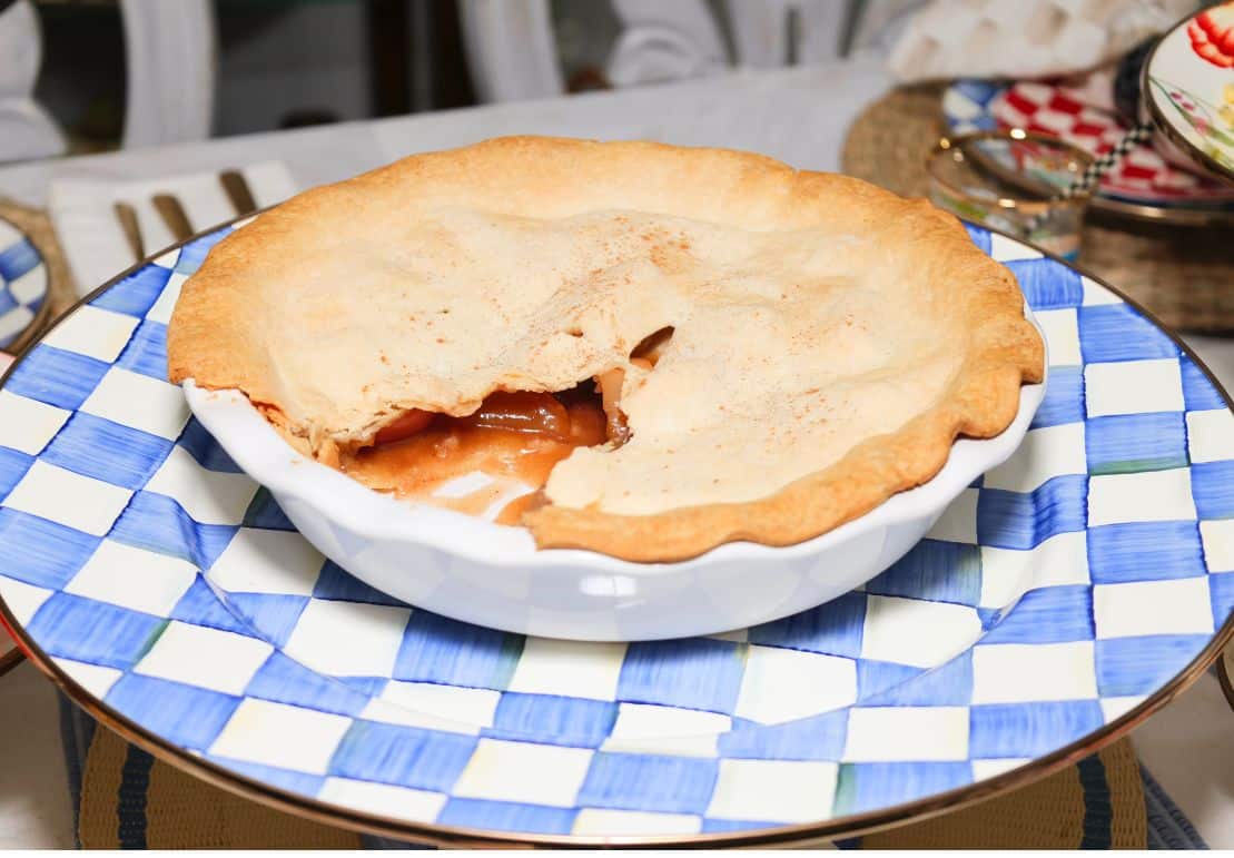 Homemade Southern apple pie with a golden crust served on MacKenzie-Childs Royal Check tableware, a classic Labor Day dessert from Shaunda Necole of The Soul Food Pot®.