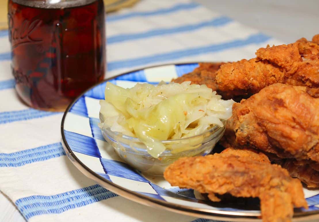 Southern fried chicken served with tender cooked cabbage for a classic soul food dinner, from The Soul Food Pot®.