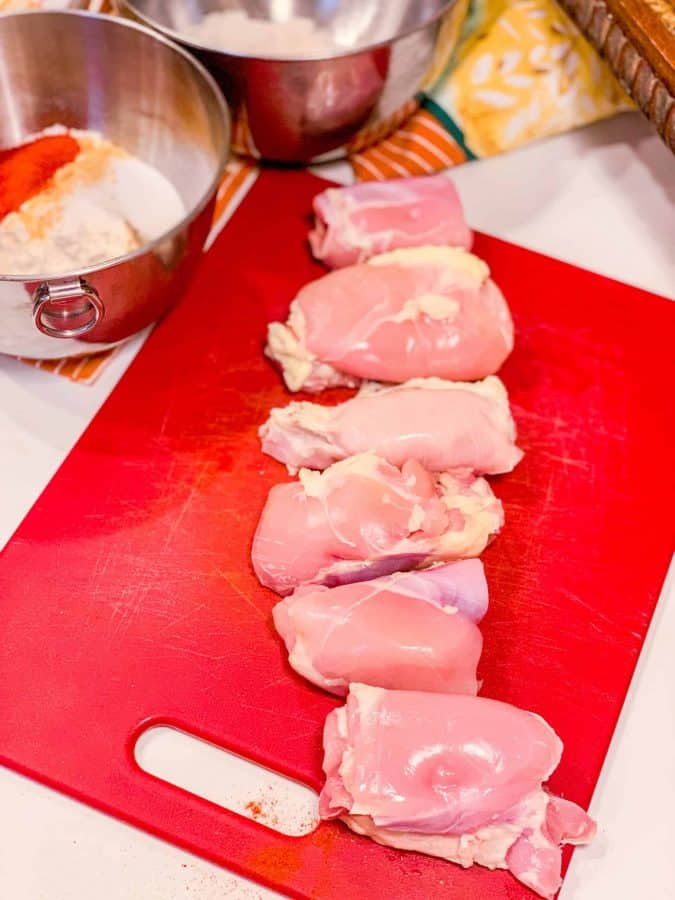 Boneless skinless chicken thighs ready to be seasoned and battered for Shaunda Necole’s Southern smothered chicken from The Soul Food Pot®.