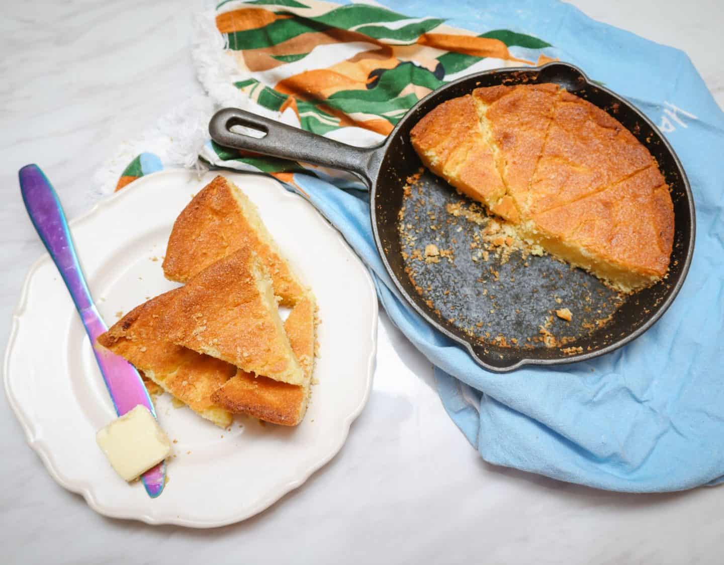 Cast-iron skillet cornbread with sliced wedges and butter