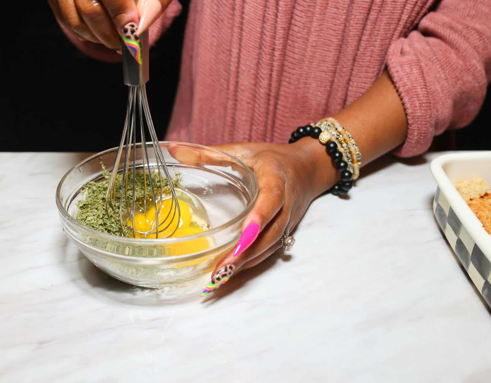 Egg and parsley being whisked together to bind the cornbread in The Soul Food Pot® chicken and dressing recipe.