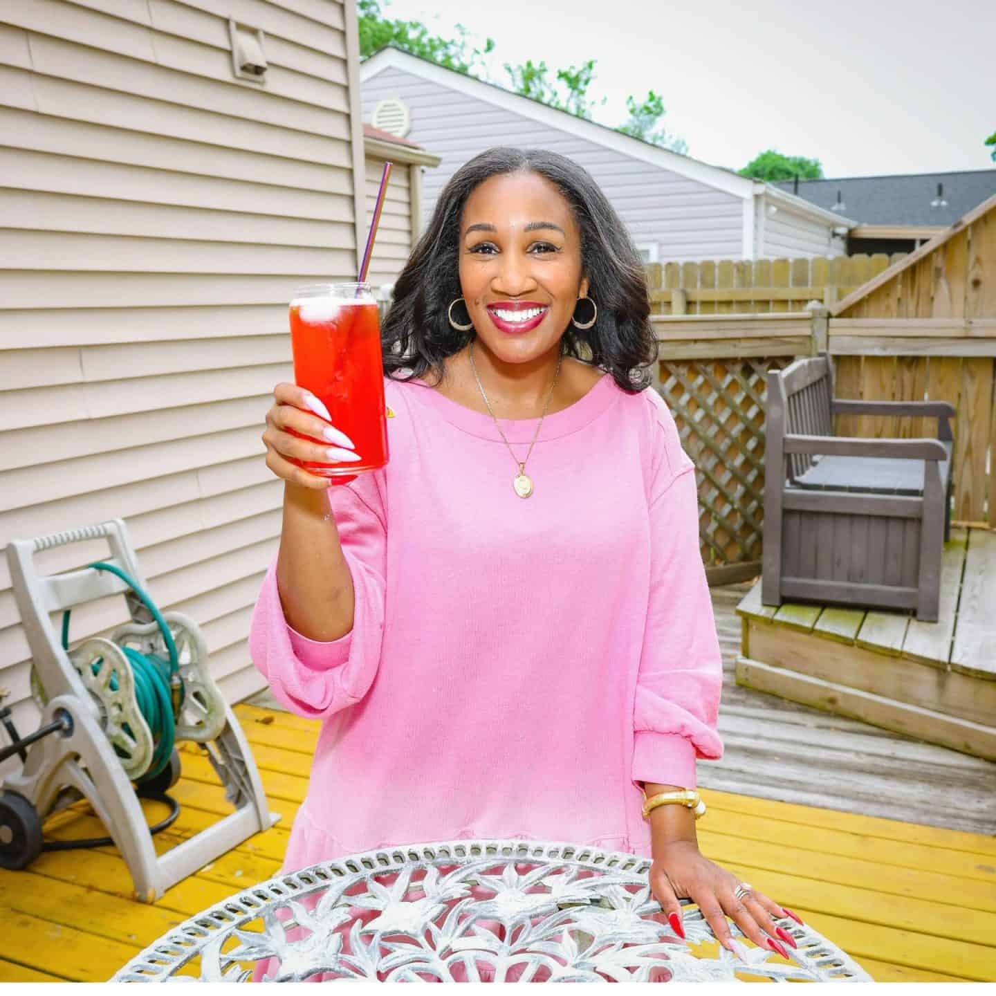 Holding red drink outdoors