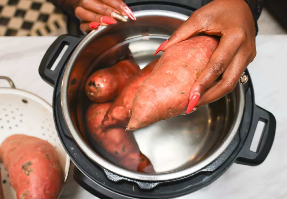 Shaunda Necole placing sweet potatoes in the Instant Pot instead of roasting them for sweet potato pie.