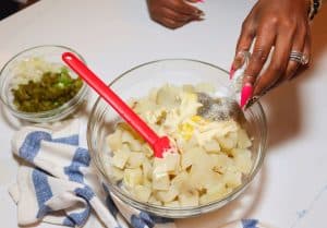 Potato salad adding the dressing and seasonings
