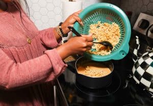 Shaunda Necole adding drained elbow macaroni