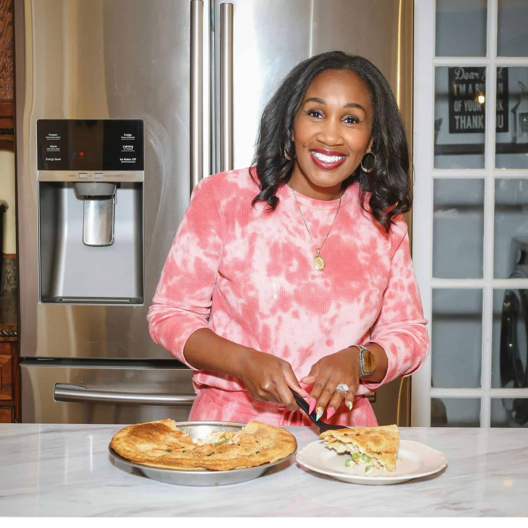 Shaunda Necole of The Soul Food Pot® slicing an easy homemade chicken pot pie with a golden crust and creamy chicken and vegetable filling.