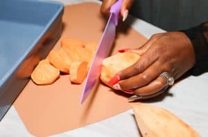 Shaunda cutting a peeled sweet potato
