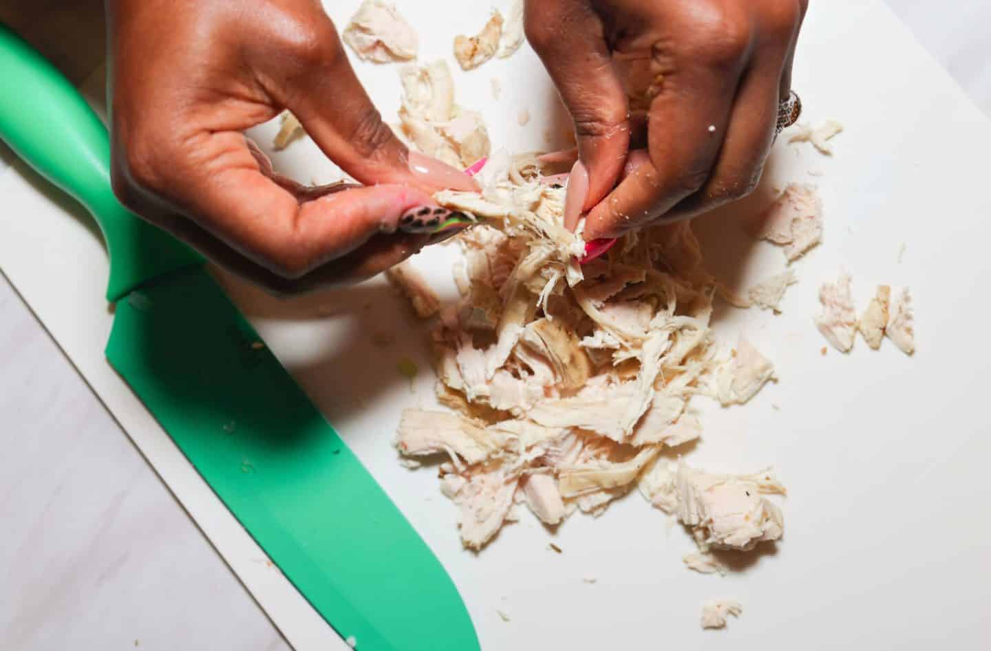 Shaunda Necole shreds cooked chicken by hand to use as an easy shortcut for The Soul Food Pot® chicken and dumplings.