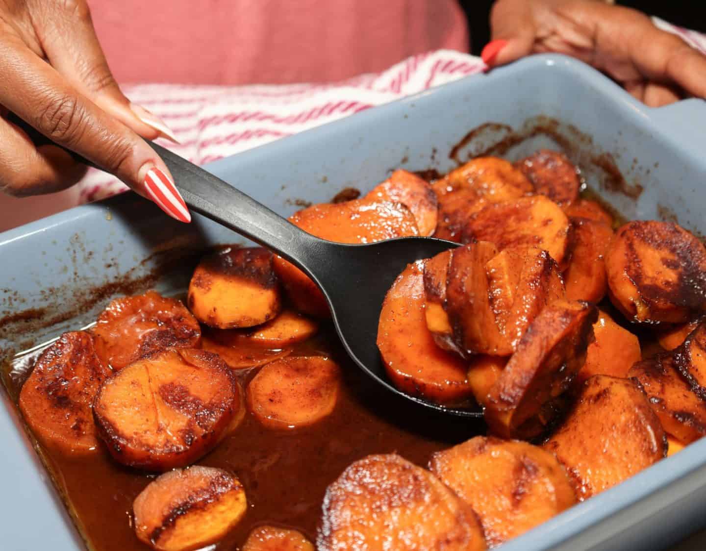 Southern candied yams coated in a glossy brown sugar and warm spice glaze, spooned from a baking dish for Shaunda Necole’s Fall Classics recipe on The Soul Food Pot®.