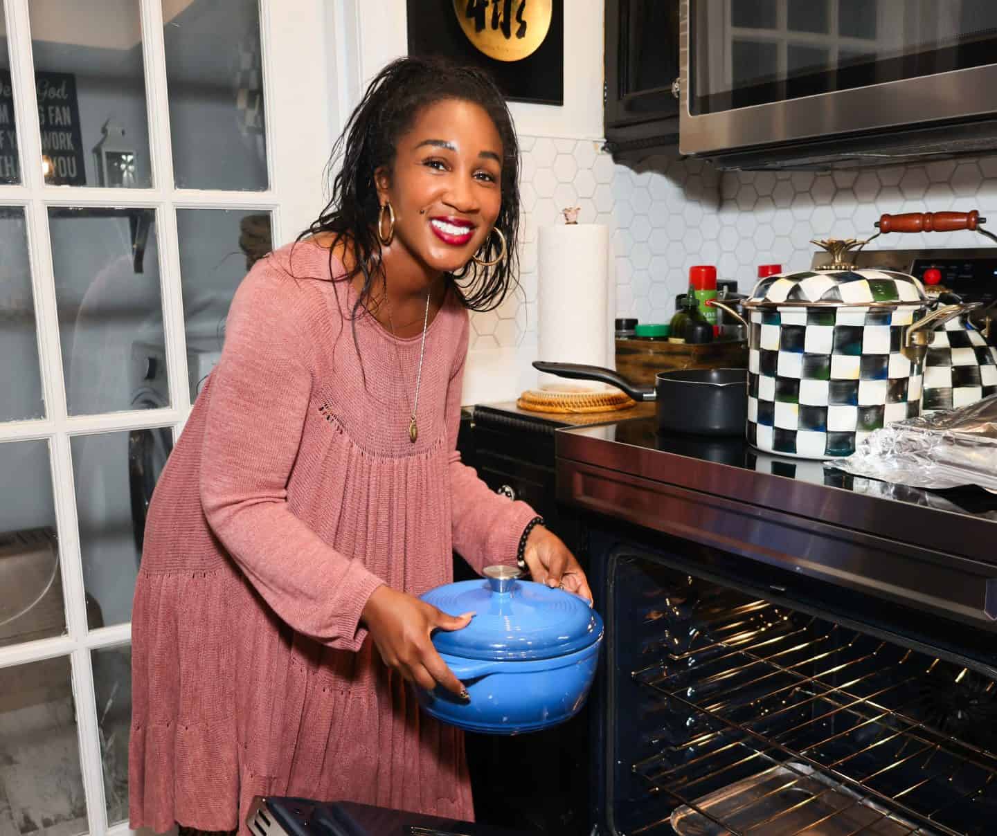 Shaunda Necole placing a covered Dutch oven into a kitchen oven, illustrating reheating and serving leftover Southern food for an easy next-day meal from The Soul Food Pot®.
