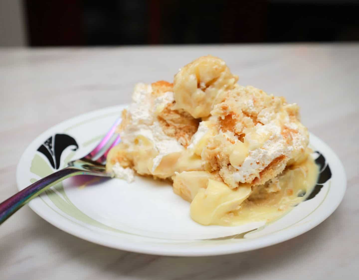 Leftover Southern banana pudding with layers of creamy pudding, sliced bananas, cookies, and whipped topping served on a plate, an easy next-day Labor Day dessert from The Soul Food Pot®.