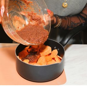 syrup being poured over sliced sweet potatoes