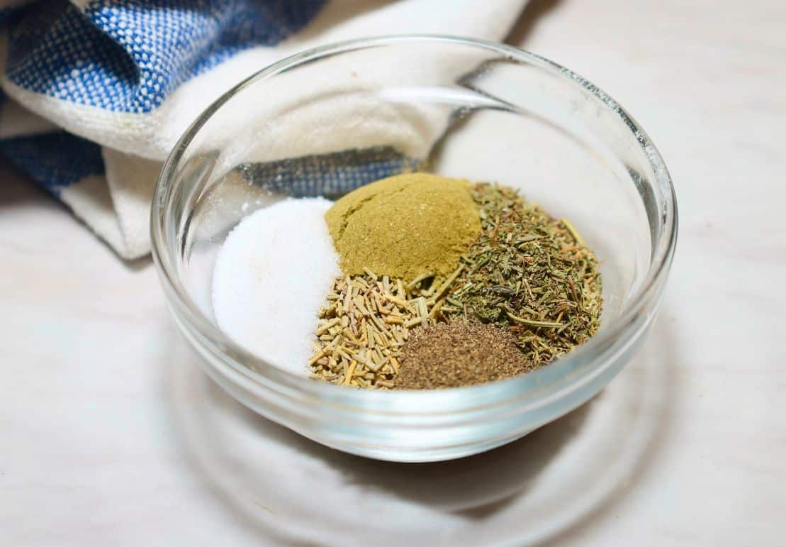 Salt, black pepper, sage, dried thyme, and rosemary measured for The Soul Food Pot® Black folks’ cornbread dressing recipe.
