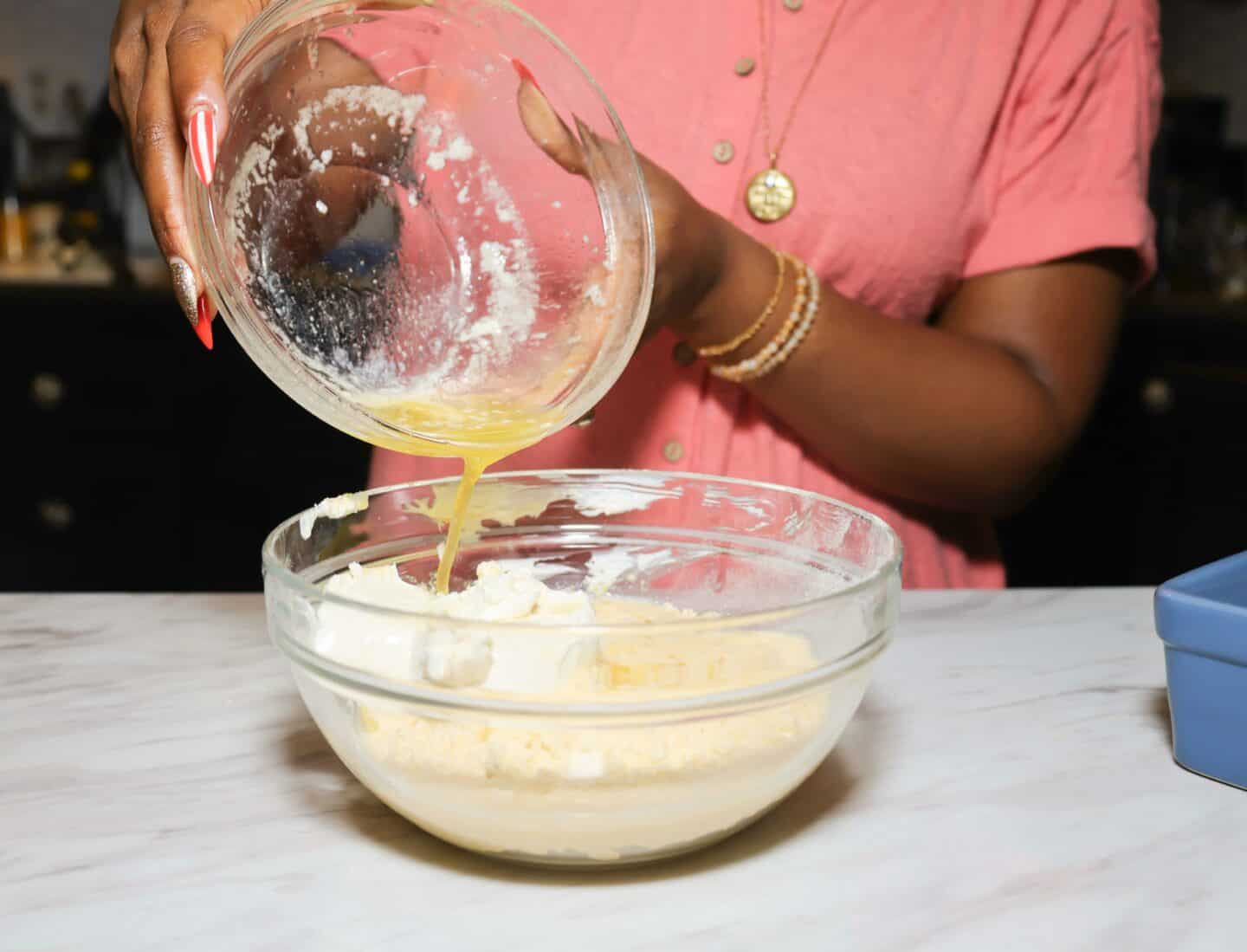 Shaunda Necole pours melted butter into yellow cornmeal, heavy whipping cream, and whipped cream cheese to make The Soul Food Pot® Southern cornbread batter.