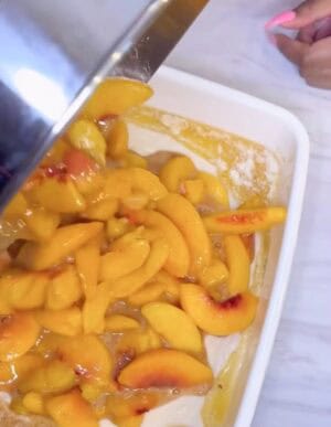 Peaches being poured over batter