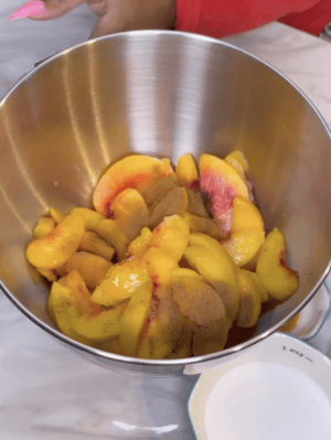 Spices added to peaches in mixing bowl