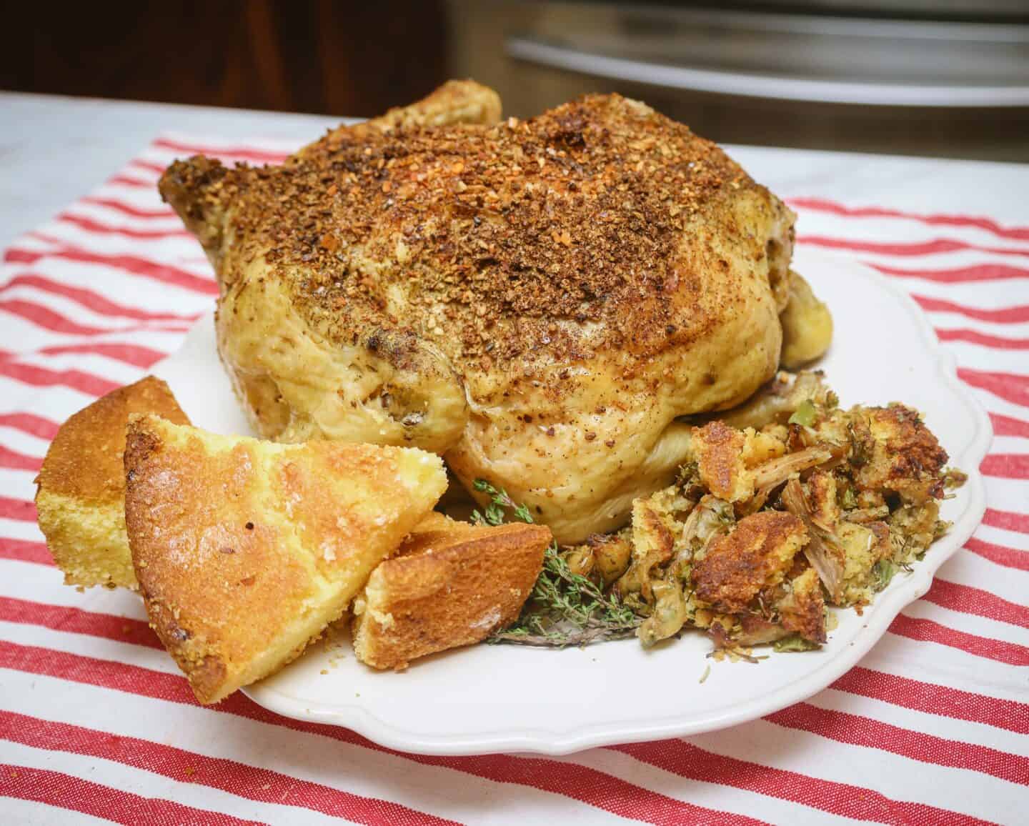 Golden Southern soul food cornbread served with seasoned roasted chicken and cornbread dressing on a platter for a classic Southern meal.